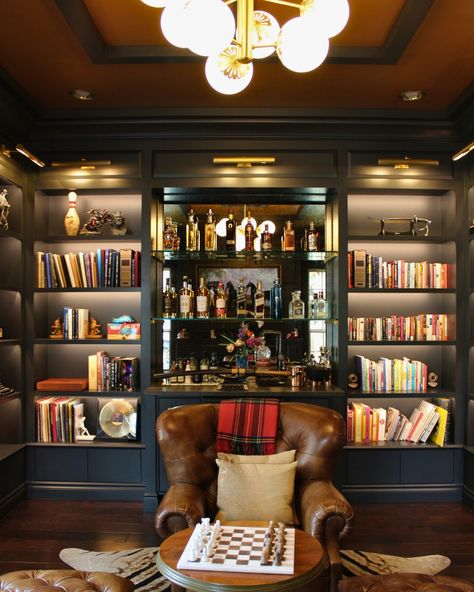 This custom black library captivates with its floor-to-ceiling built-in shelves, meticulously designed to showcase their literary treasures.

A dry bar! Complete with drawers for wine storage and a mini-fridge Floor To Ceiling Bar Shelves, Library And Bar Wall, Built In Shelves With Bar, Bookcase With Bar, Library Wine Bar, Black Library Shelves, Library Bar Design, Sitting Room Bar Ideas, Mancave Library