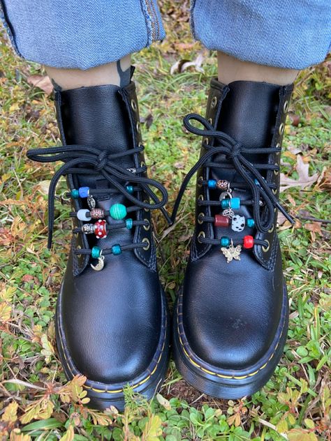 Black doc marten boots with different colored glass beads on the laces Upcycled Doc Martens, Decorating Doc Martens, Doc Martens Beads On Laces, Doc Marten Ribbon Laces, Doc Martens Beads, Beaded Doc Martens, Dr Martens Accessories, Diy Combat Boots, Shoe Charms Doc Martens