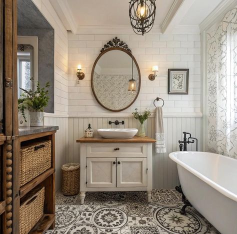 An elegant, vintage-style bathroom featuring a freestanding clawfoot tub with decorative metal feet. The room has a beautifully carved ceiling with intricate designs, a carved wooden cabinet with shelves for towels and plants, and white subway tile walls with a decorative border. Hanging pendant lights add a warm glow, and a ladder-style towel rack and vintage fixtures enhance the old-world charm. The door has carved details that match the ornate ceiling for a cohesive, luxurious feel. Claw Tub Bathroom Ideas Farmhouse, Country Modern Bathroom, Oval Bathroom Mirror Ideas, Claw Tub Bathroom Ideas, Vintage Bathroom Tiles, Small Bathroom With Clawfoot Tub, French Bathroom Design, French Country Bathroom Ideas, Country Cottage Aesthetic