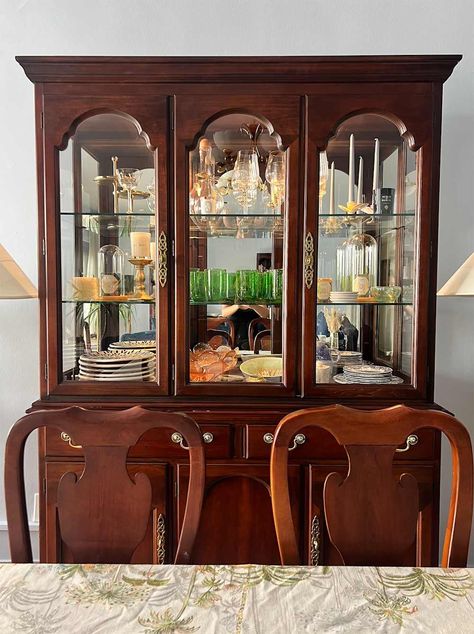 Dishes and glassware in wood china cabinet. Glass China Cabinet Display, Contemporary China Cabinet Display, How To Style China Cabinet, China Cabinet Living Room, Crystal Glassware Display, Curved Glass China Cabinet, Cherry China Cabinet, Wood China Cabinet, China Cabinet Decor