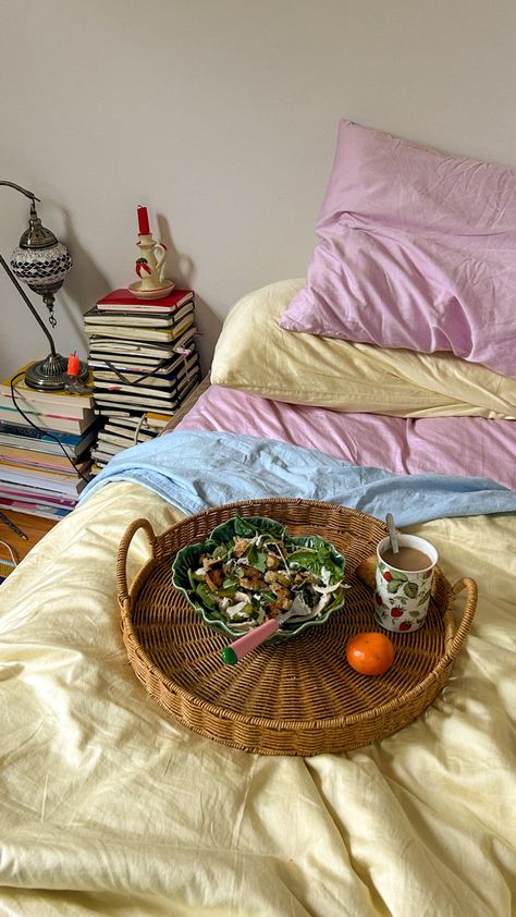 Cabbage bowl by bordallo pinheiro on a wicker breakfast tray on pastel linens in a girls cosy bedroom with a stack of books Stack Of Books Bedroom, Stack Of Magazines Aesthetic, Stack Of Books Aesthetic, Breakfast In Bed Basket, Reading Book In Bed Aesthetic, Messy Room With Books, Cabbage Bowl, Cute Bed Sheets, Student Bedroom