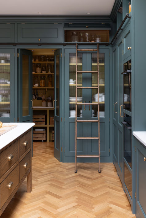 The tall run of cabinets is a striking and functional feature in this kitchen. At each end, the two double-door cupboards are dedicated crockery cupboards with fluted glass doors that open to reveal beautifully crafted oak interiors with matching oak shelves, perfect for organizing and displaying tableware. The two central doors are cleverly designed as 'secret doors' that lead directly into the walk-in pantry, blending seamlessly with the surrounding cabinetry. Tall Pantry Cupboard, Kitchen Cabinet Ladder, Kitchen With Ladder, Fluted Glass Kitchen Cabinets, Pantry With Ladder, Glass Door Kitchen Cabinets, Full Height Kitchen Cabinets, Kitchen Tall Cabinet, Kitchen With Glass Cabinets