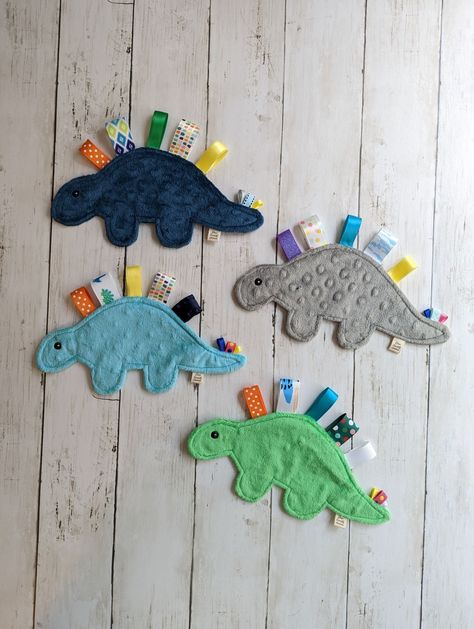 My best selling crinkle toys are now available for you to make at home! This pattern for the Due North Dino includes the supply list and instructions to make your own dino, to keep or gift as you see fit. This sweet sensory baby toy is sure to delight. Makes a crinkle sound, ribbons of different textures to feel and fiddle with, and super soft minky dot outer shell that feels oh so nice against the skin. It is machine washable and dryable because spit up happens!Measures approx 10" long and 6" high when assembled. This is for the paper pattern only. © 2022 - Kate Bierle of Due North Handmade, LLCNo part of this pattern may be reproduced without theconsent of Kate Bierle, Due North Handmade, LLC. DueNorthHandmade@gmail.comFor Personal Use Only. Facebook @DueNorthHandmadeInstagram @DueNorthH Crinkle Baby Toy, Dino Toys, Baby Diy Projects, Baby Sensory Toys, Sewing Machine Projects, Homemade Toys, Baby Sewing Projects, Baby Fabric, Fabric Toys