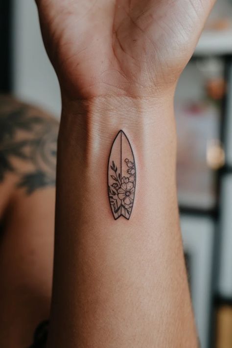 Minimalist surfboard tattoo with floral design on a person's arm. Best Friend Hawaii Tattoo, Small Skateboard Tattoo, Adventure Tattoos Women, Wave Tattoo On Foot, Wakeboard Tattoo, Paddle Board Tattoo, Hawaii Tattoo For Women, Minimalist Ocean Tattoo, Simple Arm Tattoos For Women