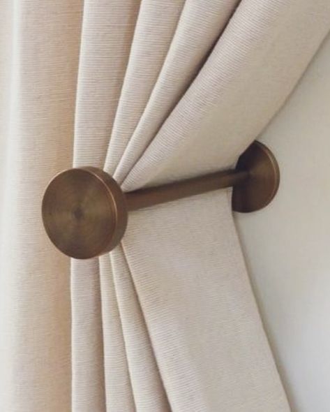 A curtain tieback is a decorative or functional accessory used to hold curtains or drapes to the side, allowing more light into the room or creating a decorative effect. They come in various styles and materials, like ropes, tassels, or metal hooks. They offer versatility in curtain styling, allowing you to change the look of the space by adjusting the position of the tiebacks or swapping them out for different styles. Overall, even though they are small details, curtain tiebacks can have... Curtain Styling, Curtain Tiebacks, Curtains Holdbacks, Brushed Bronze, Curtain Tie Backs, Functional Accessories, Curtain Hooks, Metal Hooks, Curtains With Blinds