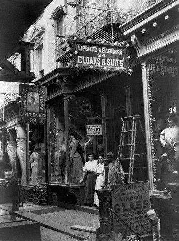 COMMERCE: Storefront of Garment Shop | New York Workers stand in the doorway of a garment shop located in the tenement "sweat shop" district. ca. 1905-1910, New York City. New York Pictures, Ellis Island, Lower East Side, Vintage New York, Bygone Era, Vintage Pictures, East Side, Street Scenes, Vintage Photographs