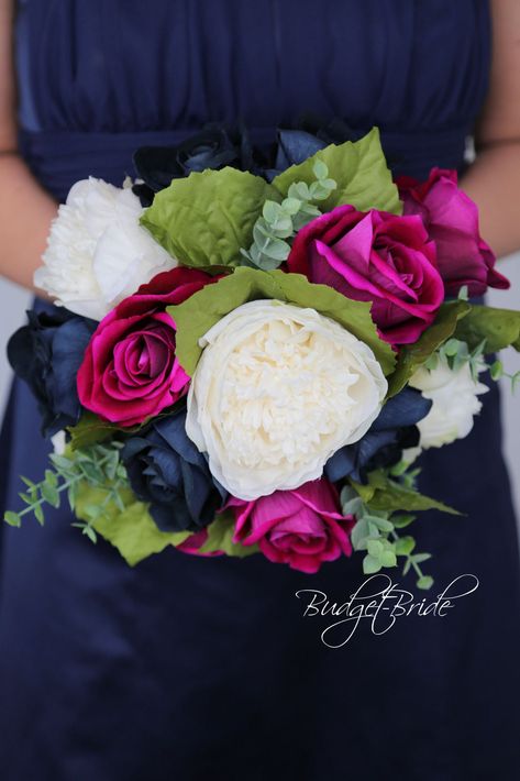 This magnificent rounded brides’ bouquet is crafted using a delicate mixture of navy blue and magenta roses of the highest quality. Accented with ivory peonies and foliage, this cheerful bouquet is sure to leave a lasting impression. The greenery accents in this collection contrast beautifully next to the soft delicate flowers, creating a bright and dazzling arrangement that is sure to turn heads. All of our bouquets are a wonderful option for destination weddings, as they can be bought in advan Magenta And Navy Wedding, Magenta Wedding Colors, Magenta Wedding Theme, Muslim Wedding Decorations, Ivory Peonies, White Wedding Flowers Bouquet, Magenta Roses, Prom Flowers Bouquet, Simple Boutonniere