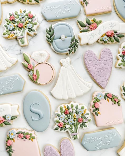 This photo stopped me in my tracks while I was scrolling through the dozens I took of this set (anyone else take WAY too many photos of every set 😅). It’s a different angle and most of the cookies are out of focus, but I love it! Swipe for a photo of the full set in a more traditional photo! This bride in bloom wildflower bridal shower cookie set was so fun to create! Their main wedding color is dusty blue so I focused on that and added in some of the floral tones from the invite. If you want... Spring Bridal Shower Cookies, Bridal Shower Cookies Floral, Spring Wedding Cookies, Wildflower Bridal Shower Cookies, Floral Wedding Cookies, Love In Bloom Cookies, Love Is In Bloom Cookies, Blue Bridal Shower Cookies, Love In Bloom Bridal Shower Ideas