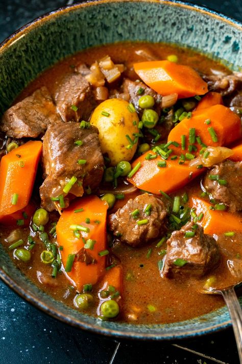 This Dutch Oven Beef Stew features meltingly tender beef simmered in a velvety red wine beef broth with potatoes, celery, carrots and peas. It's a classic, rich, long-simmered stew that screams comfort and you'll want this on repeat all Winter long! #beefstew #classicbeefstew #comfortfood #dutchovenrecipes #dutchovenbeefstew #winterrecipes #beefrecipes Dutch Oven Beef Stew, Dutch Oven Beef, Oven Beef Stew, Irish Stew Recipe, Guinness Stew, Guinness Beef Stew, Irish Beef, Beef Barley, Irish Stew