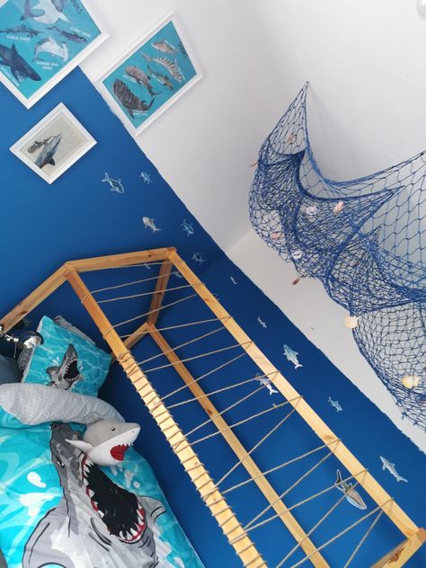 Shark bedroom, fish netting, shark bedding, shark illustrations, shark wall decals Shark And Dinosaur Bedroom, Kids Shark Bedroom, Toddler Shark Room, Shark Toddler Room, Shark Bedroom Decor, Shark Bedroom Boys, Boys Shark Bedroom, Shark Room Ideas, Shark Room For Boys