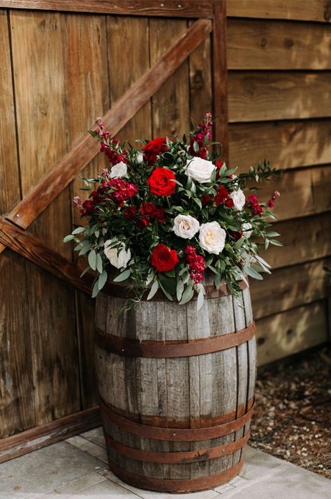 A Rustic And Elegant Barn Wedding In Bayou Country Wine Barrels With Florals And Barn Floral Arrangement On Wine Barrel, Christmas Wedding Rustic, Christmas Wedding Arbor Ideas, Christmas Country Wedding Ideas, December Wedding Decorations Wedding Table Decor, Christmas Rustic Wedding, Country Christmas Wedding Ideas, Christmas Wedding In Florida, Cowboy Christmas Wedding