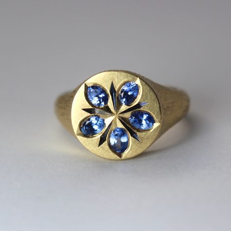 A fairly low lying 9ct yellow gold round top signet ring, 14mm diameter across the top. The top has 5 oval ceylon blue sapphires flush set and engraved to be elongated pointed petal shapes. There are engraved and blackened points between each sapphire petal to look like a smaller star behind the main sapphire star. This represents a starflower borage, which represents courage. Sapphire Signet Ring, Wizard Jewelry, Witch Rings, Bridal Jewellery Inspiration, Accesories Jewelry, Cute Engagement Rings, Gold Bracelet Cuff, Chunky Jewelry, Dress Rings