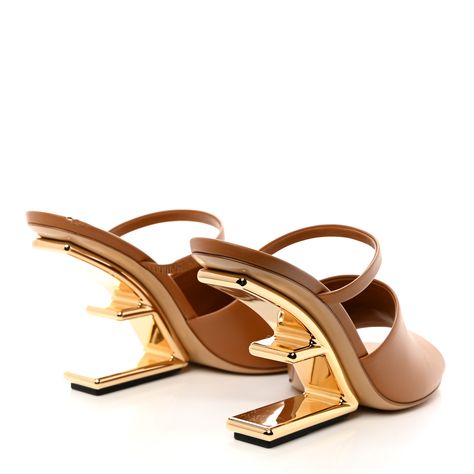 This is an authentic pair of FENDI Calfskin Fendi First 95mm Slide Sandals 37.5 in Caramello. These are stylish sandals are crafted of brown calfskin leather. The gold heel has a diagonal F shape with rubber padding underneath. These slide sandals feature a padded lambskin footbed for comfort. Fendi Heels, Fendi First, Stylish Sandals, Gold Heels, Slide Sandals, Calf Skin, Fendi, Sandals, Heels