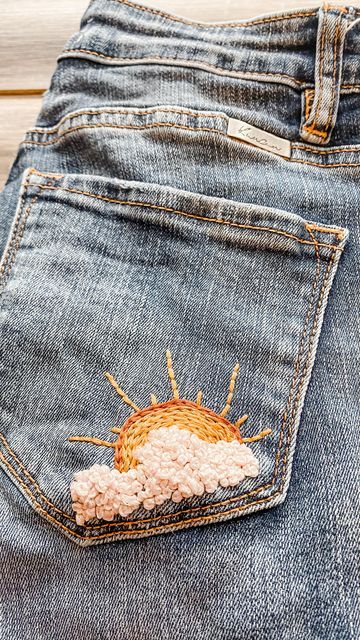 LaineIrene on Instagram: "Sun and clouds from my new summer stick and stitch pack 🌤 I love how this turned out on an old pair of jeans of mine! Now I’m so excited to wear these jeans again! Grab your Summer Fun stick and stitch pack in my Etsy shop now ☀️ link in profile! . . . . . #dmcembroidery #diyembroidery #embroideredjeans #modernembroidery #embroideredclothing #sunshine #chasethesun" Embroidery Ideas Jeans, Jeans Hand Embroidery, Embroidery In Denim, Sunshine Embroidery Design, Embroidery Jeans Pocket, How To Embroider Clouds, Jean Embroidery Ideas Pockets, Embroidery Jeans Ideas, Hand Embroidery On Jeans