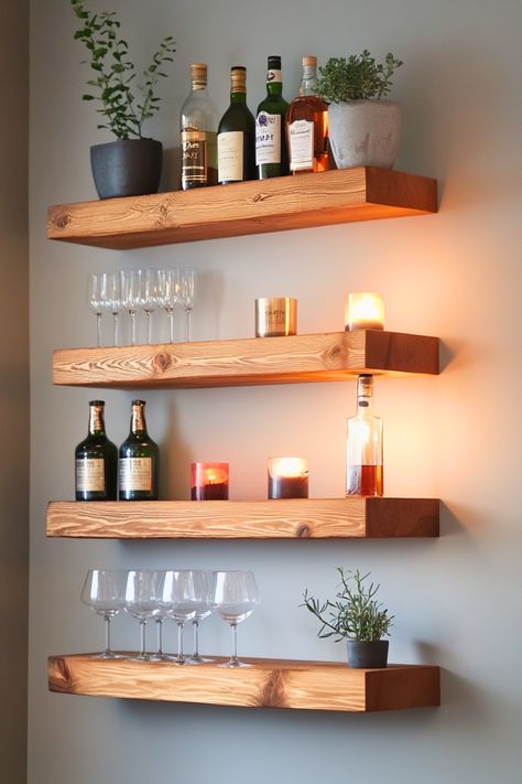 Ever thought of upgrading your bar area with floating shelves? These sleek wood, glass, or metal shelves maximize your wall space without taking up floor room, making them ideal for modern home bars. I’m all about how they blend function with minimalist decor ideas, giving your living room or bar area a clean, streamlined look. Perfect for showcasing your liquor and glassware collection in style. Ready to elevate your bar setup? Home Wine Bar Ideas, Glass Shelf Ideas, Tiny Bar Ideas, Bar Setup Home, Floating Shelves Bar, Wall Bar Ideas For Home, Floating Bar Table, Wall Bar Ideas, Dining Room Floating Shelves