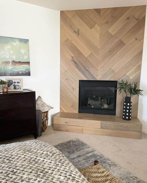 Wood-look shiplap in a herringbone pattern with an inset black fireplace creates an eye-catching feature wall. A patterned black and white vase sits on the wooden tile hearth. Wood Tile Wall Accent, Vertical Shiplap Fireplace Wall, Herringbone Fireplace Surround, Herringbone Shiplap, Tile Hearth, Herringbone Fireplace, Fireplace Accent Walls, Inset Fireplace, Wood Wall Tiles