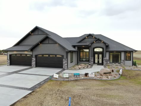 New Construction Home Ideas Exterior Ranch, New Homes Exterior, House And Garage Different Colors, Houses With Big Garages, Black Siding Stone House, Ranch Homes Exterior, Gray And Black Stone House Exterior, Dark Blue Siding House With Stone, Dark Grey House Exterior Charcoal Front Doors Do You Match Garage?