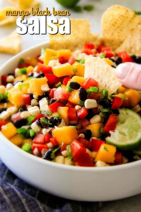 Mango Black Bean Salsa - Real Housemoms: Mango Black Bean Salsa is fresh, vibrant & super simple to make! It’s a refreshing make-ahead appetizer or the perfect accompaniment to grilled entrees! #bell-pepper #black-bean #cinco-de-mayo #cookout #corn #garlic #jalapeno #lime-juice #mango #red-onion #salsa #tomatoes #appetizers-2 #recipes #realhousemoms Salsa Party, Party Food For A Crowd, Black Bean Salsa, Bean Salsa, Make Ahead Appetizers, Party Bites, Anniversary Party Ideas, Best Food Recipes, Ideas Birthday Party