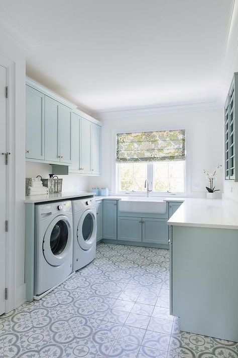 U-shaped laundry room featuring blue cabinetry and nickel knobs fitted with a farmhouse sink under a window dressed in a green and blue floral roman shade. Nautical Laundry Room, Calm Place, Inspirational Homes, Laundry Mudroom, Blue Laundry Rooms, Laundry Room Storage Shelves, Room Storage Diy, Laundry Ideas, Dream Laundry Room