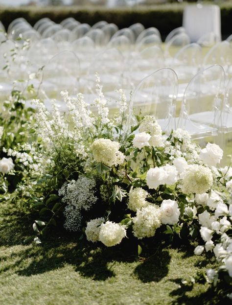 Set the tone for your ceremony with these lux acrylic ghost chairs. Check out more of Chanel + Aaron's gorgeous Klentner Ranch wedding over on the ol' blog. You'll also find real wedding inspiration at some of the most premier venues in the US. White Green And Black Wedding, Ghost Chair Ceremony, Green And White Wedding Decor, White Flowers Down Aisle, White Flower Lined Aisle, White Flowers Lining Aisle, Klentner Ranch, All White Floral Installation, Green And White Wedding Flowers