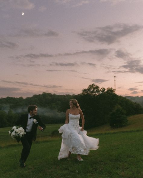 Bride and groom running under the moonlight together. Beautiful wedding photos at night. Wedding photos with the colorful dark sunset. Bright moon in the sky. Running in the grass under moonlight. Candid wedding photography. Wedding Running Photo, Wedding Pictures At Night, Bride And Groom Candid Photos, Wedding Photos Running, Wedding Photos At Night, Wedding Photos On The Beach, Wedding Family Portraits Group Shots, Wedding Photo Ideas Candid, Night Time Wedding Photos