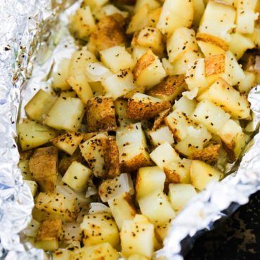 A foil packet filled with cubed roasted potatoes in foil on a baking pan. Diced Potatoes In Oven, Foil Potatoes, Potato Packets, Fish Sides, Foil Packet Potatoes, Steak Burger, Food Sides, Potatoes In Oven, Foil Packet Meals