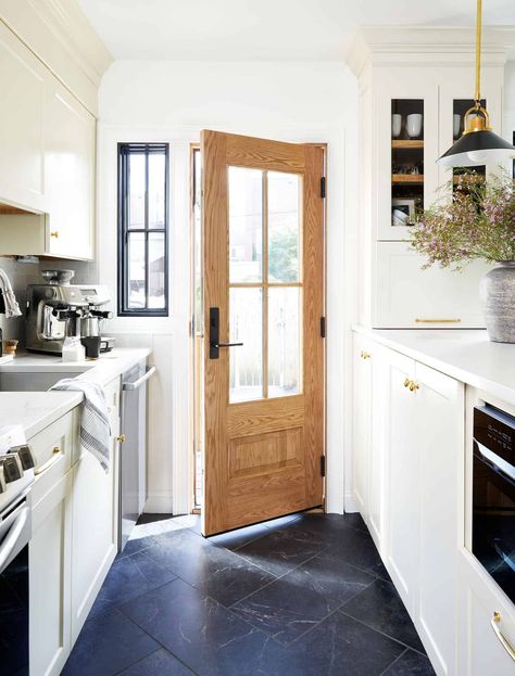 creamy cabinets and black tile floor in kitchen