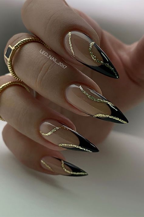 Classy stiletto black French tip nails with gold glitter swirl nail art Nails To Go With Black Outfit, Black Gold Tip Nails, Black French Tip Nails Almond With Gold, Gel X Black French Tip, Gorgeous Almond Nails, French Black Nail Designs, Wedding Nails Black And Gold, Black Art Deco Nails, Gold Black French Nails