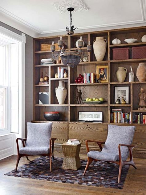 Wood finishes are warm and inviting – highlight the unique beauty of the wood by purposefully leaving empty space around collectibles so that the grain is visible, and choose objects in lighter colors and sculptural shapes that stand out against the stain. Mid Century Bookcase, Book Cases, Library Ladder, Basement Playroom, Decorating Bookshelves, Bookshelves In Living Room, Wood Bookshelves, Built In Bookcase, Retro Home Decor