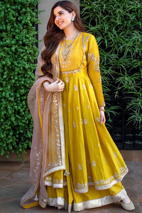 Featuring a glaze mustard anarkali in silk chanderi base with kashmiri tilla, pearls, and gota embroidery. It is paired with a matching crushed cotton skirt and a daisy ivory silk organza dupatta.The biggest luxury blowout end of season sale up to 50% off Anarkalis to Adore.#Perniaspopupshop #womenswear #ethnic #whatiworewastrending #ppuslove #anarkaliset #organza #chanderisilk #cotton #gotaembroidery #pearlsembroidery #weddingwear #festivewear #sangeet #haldi #weddingceremony Long Frock Suit, Indian Long Frocks, Simple Anarkali Dress, Long Anarkali Gown, Bridal Anarkali, Anarkali Frock, Anarkali Churidar, Haldi Outfits, Designer Anarkali Dresses