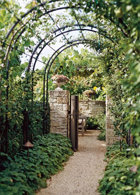 Arch trellises connected within a metal framework line up to create a tunnel that guides visitors from one area to the next. The striking construction frames a foliage-lined gravel walkway leading to a stone-walled outdoor room. #archtrellis #gardenarch #archwayideas #landscaping #bhg Metal Arbor, Garden Arch Trellis, Arch Trellis, Garden Vines, Garden Arbor, Garden Arches, Garden Entrance, Backyard Pergola, Have Inspiration