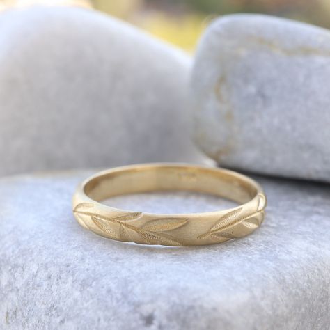 "Celebrate your love with our Leaf Engraved Wedding Band. This nature-inspired gold ring features delicate leaf engravings, making it a beautiful choice for wedding rings. The textured gold adds a touch of elegance, creating a unique and meaningful piece. Whether as a wedding band or a symbolic accessory, this engraved ring captures the essence of nature and enduring love. Measurements: * Material: High Quality Solid Gold 14k or 18k * Ring Width: 3.00 m\"m * Ring Height (Thickness): 1.20 m\"m ------CUSTOMIZATION------ ♥ Feel free to contact me for any other customization to your preferences. How to order: * Ordering is easy! Just use the Menu Bar to pick the size and gold material you want for the ring, and then place your order. We'll make the wedding band just for you, and it will be rea Nature Wedding Band, Patterned Wedding Band, Engraved Wedding Band, Olive Leaf Ring, Textured Wedding Band, Wedding Band Gold, Leaf Wedding Band, Wedding Band Engraving, Nature Inspired Rings