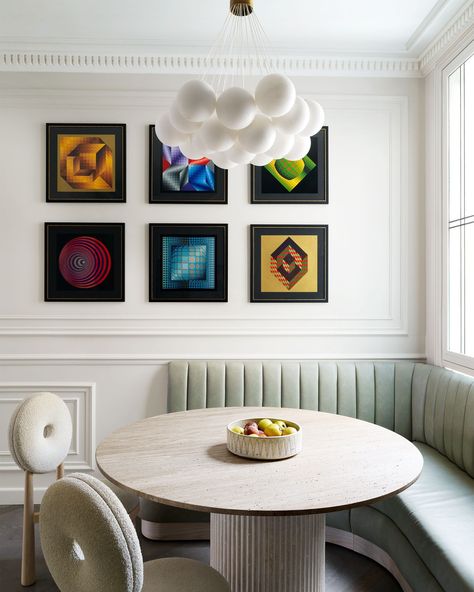 We wouldn’t mind being in a tight corner if it was as chic as this one! In a Paris apartment, designer Sarah Dray (@sarah.dray) converted a kitchen nook into the perfect breakfast area, complete with a custom channel-tufted banquette, donut-shaped chairs by Emmanuelle Simon, and an array of artwork by Victor Vasarely. “The aesthetics of Parisian buildings fascinate me,” Dray says. “I’ve never seen anything quite so beautiful.” Click the link in the bio to tour the rest of this opulent Parisi... Tufted Banquette, Travertine Table, Built In Seating, Parisian Apartment, Kitchen Nook, Paris Apartments, Built In Bench, Breakfast Area, Art Deco Inspired