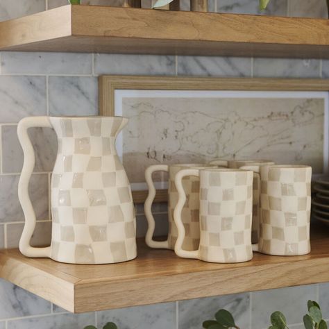 The squiggles & checks of the ceramic Emil Pitcher bring an element of play to tablescapes. This versatile, food-safe vessel features an organic shape, squiggle handle, & two-toned, abstract checkerboard pattern of alternating textured tan & smooth white glazed checks. Neutral hues contrast beautifully with the on-trend, statement design to make this piece stand out as a vessel for serving drinks or holding a floral arrangement. 6.5in W x 5in D x 7.75in H Finish: Off-white Material: Ceramic Shop Cute Dishes, Ceramic Kitchenware, Ceramic Glazes, Kitchen Ware, Pitcher Ceramic Pottery, Clay Pitcher, Neutral Dinnerware, Easy Kitchen Updates, Ceramic Pitcher Handbuilt