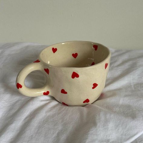 Infuse your mornings with warmth and affection using this delightful handmade ceramic mug. Expertly crafted with meticulous attention to detail, this beige mug is beautifully decorated with delicate red hearts, offering a charming and cozy aesthetic that's perfect for bringing a touch of love to your daily routine. This mug stands out for its handcrafted uniqueness--no two mugs are exactly alike, making each piece a special work of art. The delicate heart pattern is hand-painted, reflecting the Cup Ceramic Painting, Painting Mugs Aesthetic, Cute Clay Cups, Cute Cups And Mugs, Cups Painting Ideas, Ceramic Mugs Painting, Mug Painting Aesthetic, Cute Cups Aesthetic, Aesthetic Mug Painting