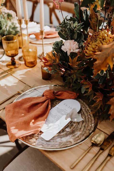 This autumnal wedding tablescape by wedding stylist Hannah baskett shows how you can mix rustic styling with gold touches to create a stunning place setting for your wedding guests. Gold charger plates sit perfectly on top of rattan place mats and when paired with modern wedding stationery and burnt orange knotted napkins the whole look is perfectly cohesive. Orange Wedding Table Setting, Knotted Napkins, Fall Wedding Place Settings, Wedding Personal Touches, Fall Wedding Tablescapes, Wedding Plate Setting, Rustic Wedding Table Setting, Wedding Table Details, Rustic Placemats