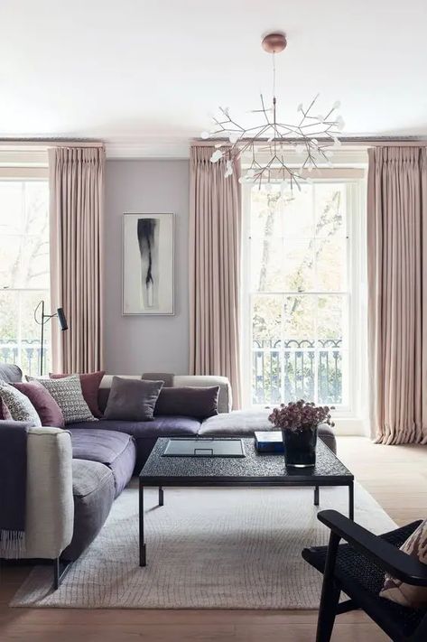 a glam living room with grey walls, a large grey and purple sectional, pink pillows and blush curtains Good Living Room Colors, Furnitur Ruang Keluarga, Layered Curtains, Room Wall Painting, Revere Pewter, Living Room Color Schemes, White Upholstery, Living Room Trends, Room Color Schemes