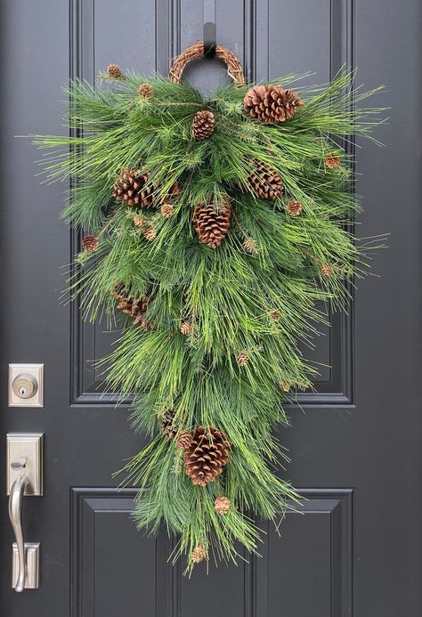 Christmas Teardrop Swag with Pine and Pinecones - TwoInspireYou Swag Front Door, Cedar Swag Diy, Teardrop Christmas Swag, Christmas Teardrop Wreath, Pine Boughs Decorations, Christmas Swag Ideas, Christmas Swags For Front Door, Christmas Swags Ideas, Pinecone Swag