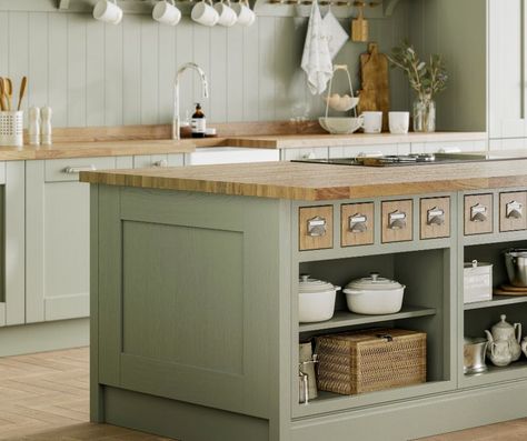 a muted green kitchen in a sage like shade with wooden worktops, wooden spice drawers and open green shelves with crockery featured on a woodern floor Laura Ashley Kitchen, Island Drawers, Modern Shaker Kitchen, Sage Kitchen, Sage Green Kitchen, Hacks Kitchen, Kitchen Showroom, Shaker Kitchen, Kitchen Cabinet Colors