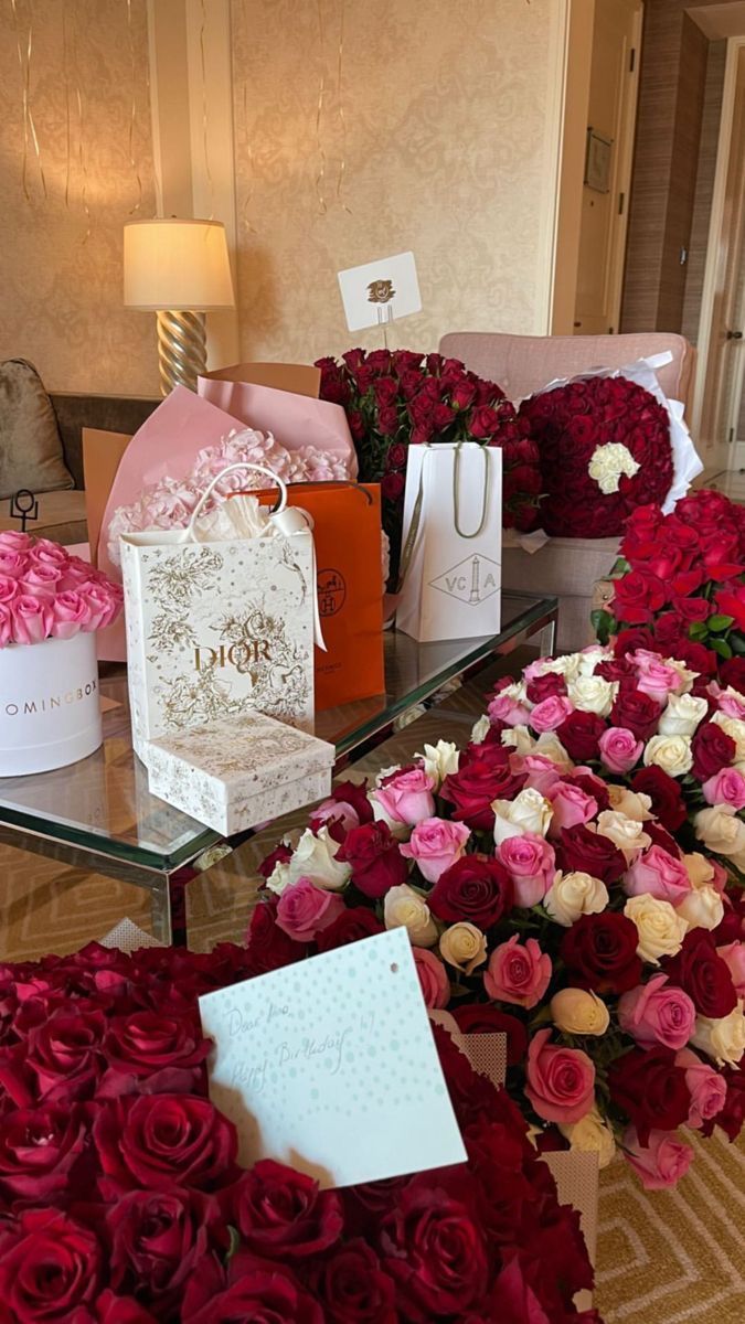 roses and other flowers are on display in a room with many boxes, bags, and greeting cards