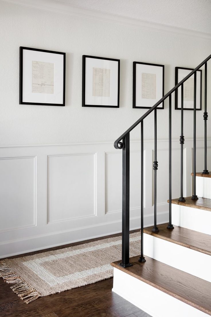 a staircase with pictures on the wall above it