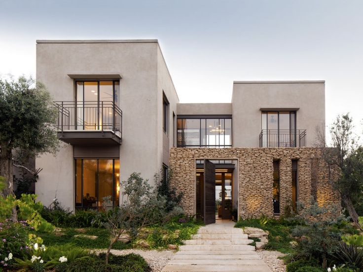 an exterior view of a modern home with stone steps leading up to the front door