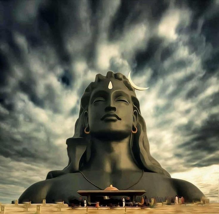 a large statue with clouds in the background