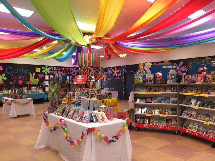 the inside of a children's book store decorated with rainbow streamers and decorations