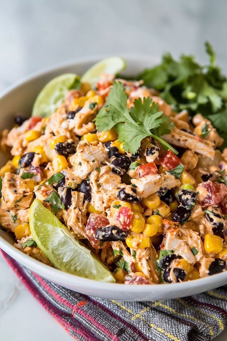 a white bowl filled with mexican chicken salad and garnished with cilantro