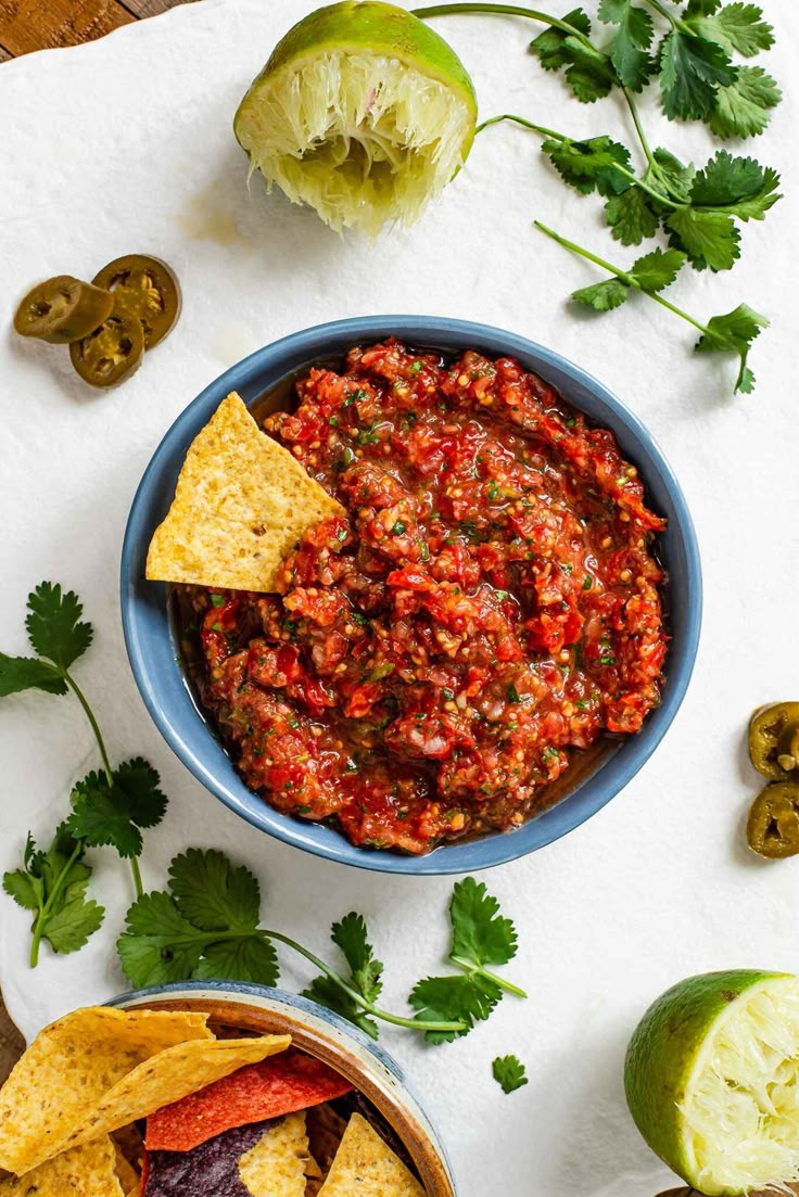 salsa in a bowl with tortilla chips and cilantro on the side