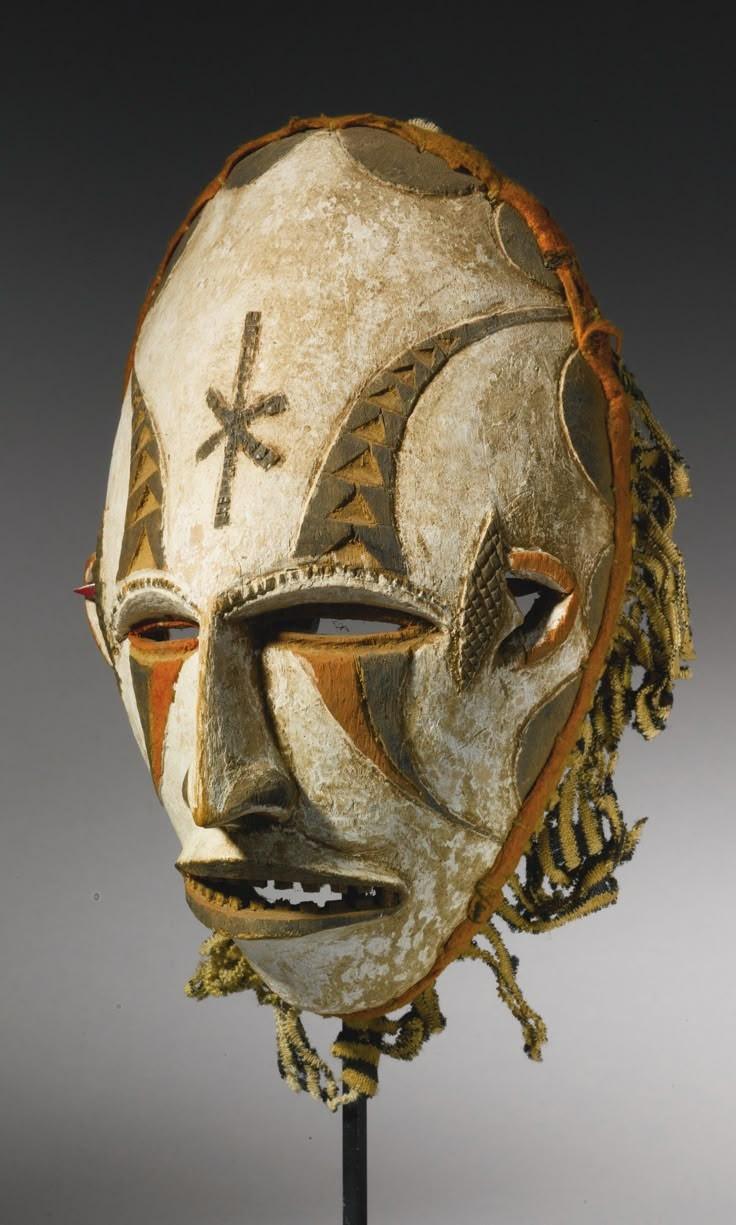 an african mask on a wooden stand