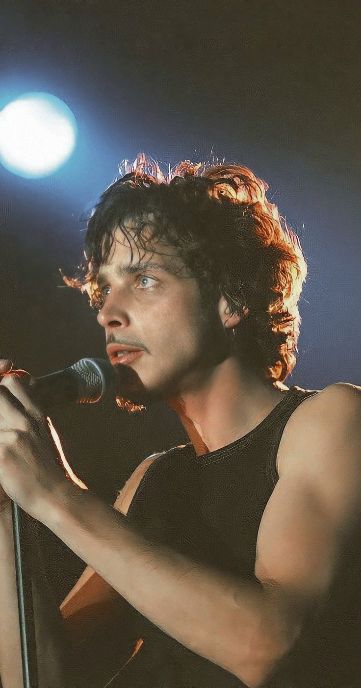 a man with curly hair holding a microphone