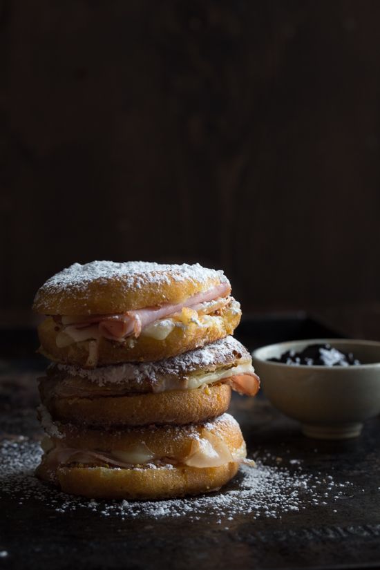 a stack of doughnuts sitting next to a bowl of powdered sugar