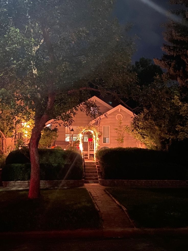 a house is lit up at night with the lights on